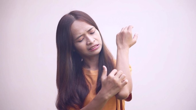 手臂皮肤发痒的亚洲女性。