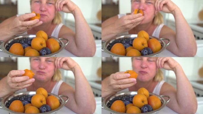 胖乎乎的金发女郎狼吞虎咽地吃着一颗杏子