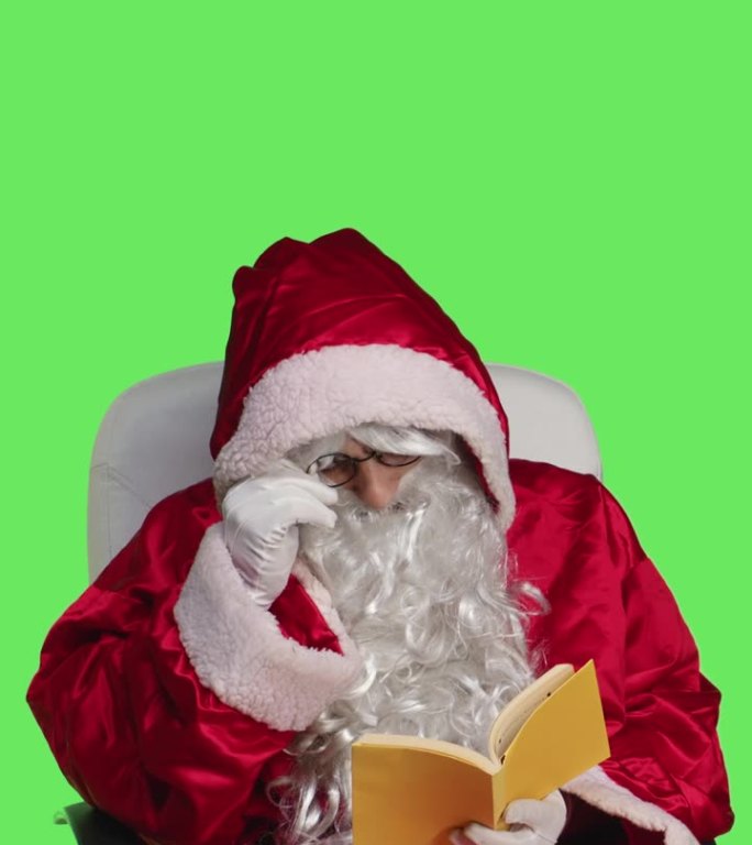 垂直视频圣诞老人阅读小说书的正面视图