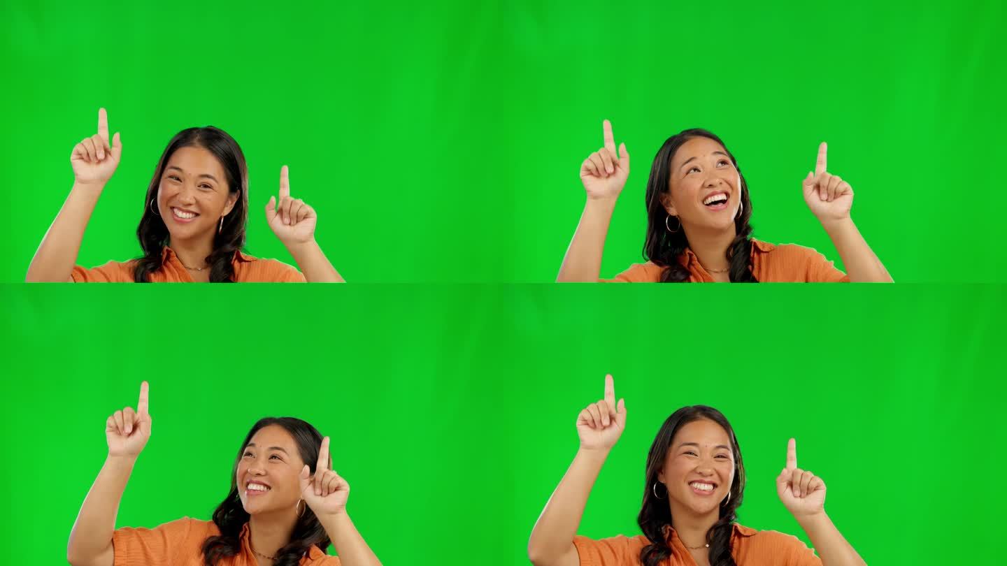 快乐的亚洲女人，指着绿屏幕上的广告，背景是工作室。女性指的是广告，促销折扣或交易的通知，提醒或新闻的