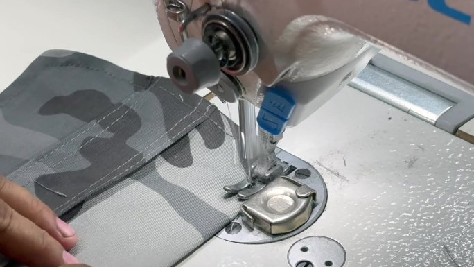 服装平缝机的特写镜头。成衣的单针缝合