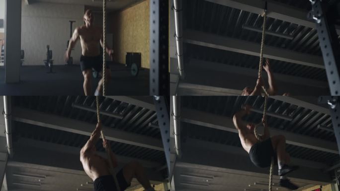 英俊的训练男子与肌肉裸露的躯干攀绳在健身房，有氧运动健身