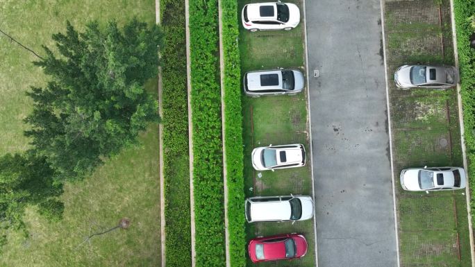 无人机飞过停在室外停车场的汽车的航拍画面，中国
