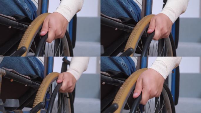 缠着绷带的手旋转着旧轮椅的轮子，在房间里走动。康复