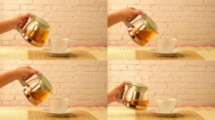 女人用手把热茶倒进一个白色的杯子里