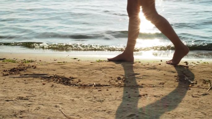 女人的腿沿着波罗的海的海岸走