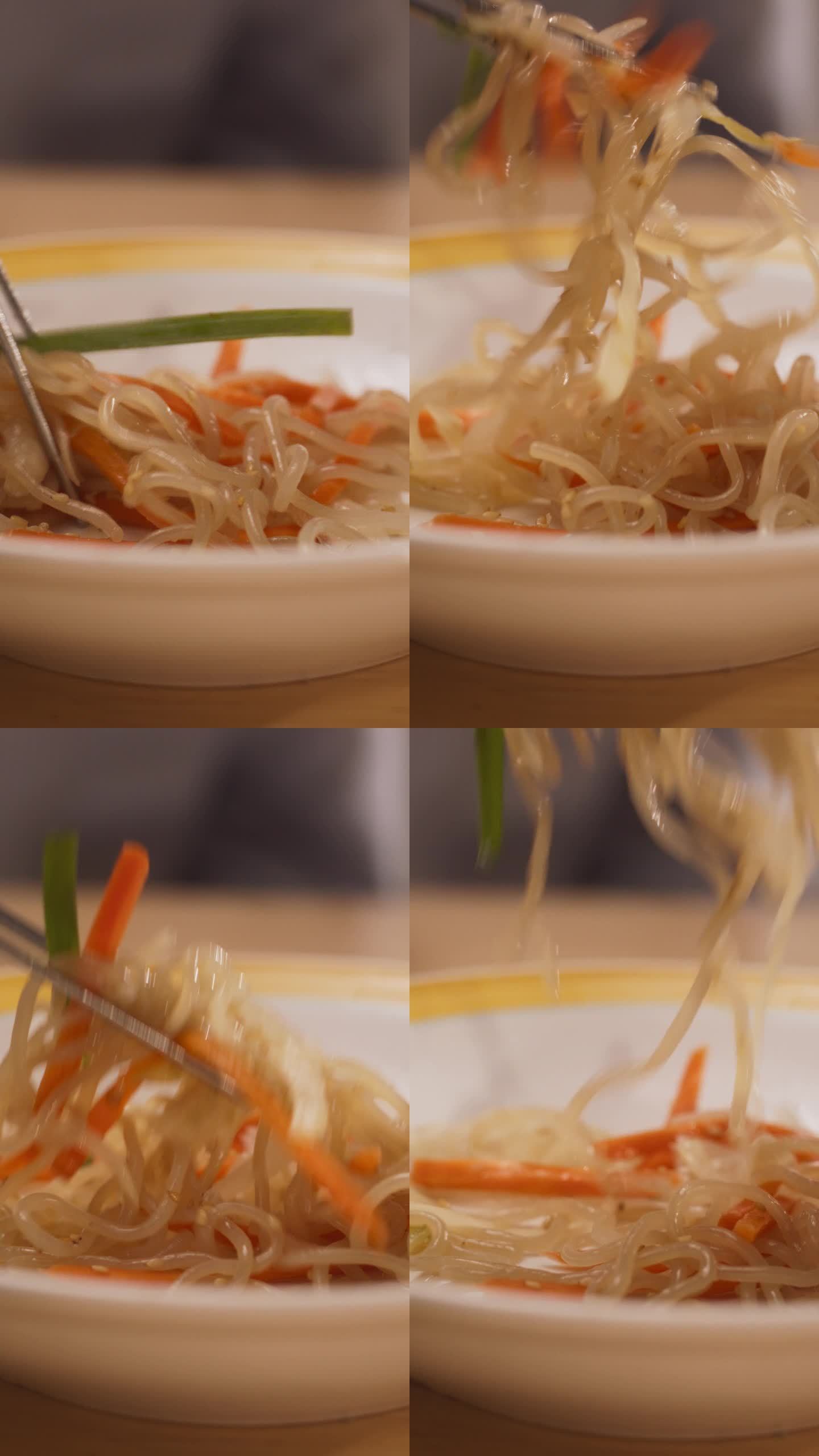 垂直屏幕:接近素食韩国配菜:匿名的人用金属筷子夹玻璃面条。餐桌上的亚洲素食。健康的传统亚洲食品
