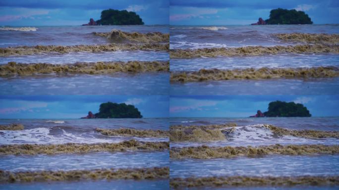 大海里的大浪打在沙滩上，海水浑浊。