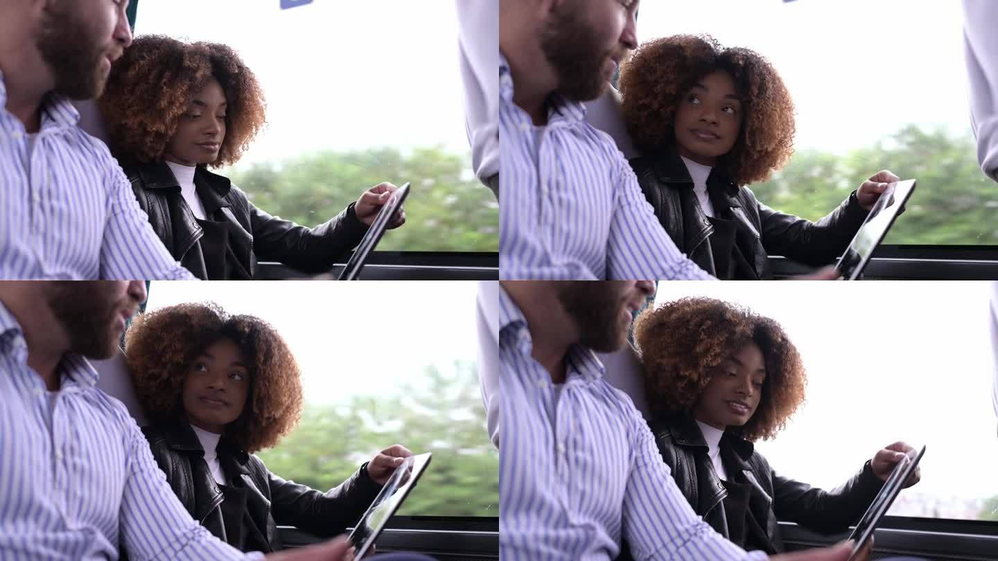 一男一女在公共汽车上看平板电脑