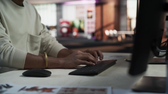 一位印度男子在公司办公室的台式电脑前工作的特写肖像。年轻男经理上网、网上购物、阅读朋友和同事的社交媒