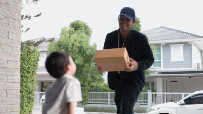 快递员带着愉快的心情把盒子送到了一个男孩和母亲的家里