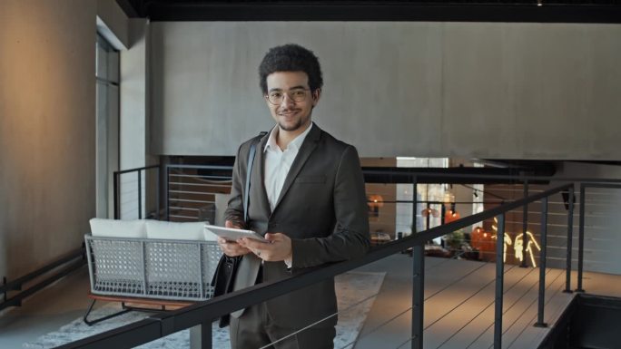 办公室大厅里带着平板电脑和包微笑的阿拉伯商人画像