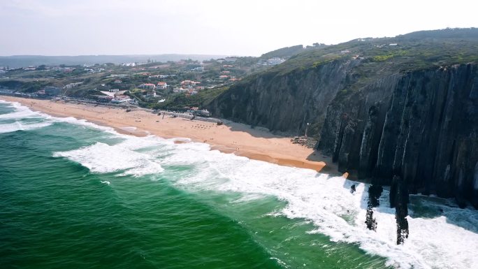 4K鸟瞰大西洋海浪和葡萄牙普拉亚格兰德海滩的岩石悬崖
