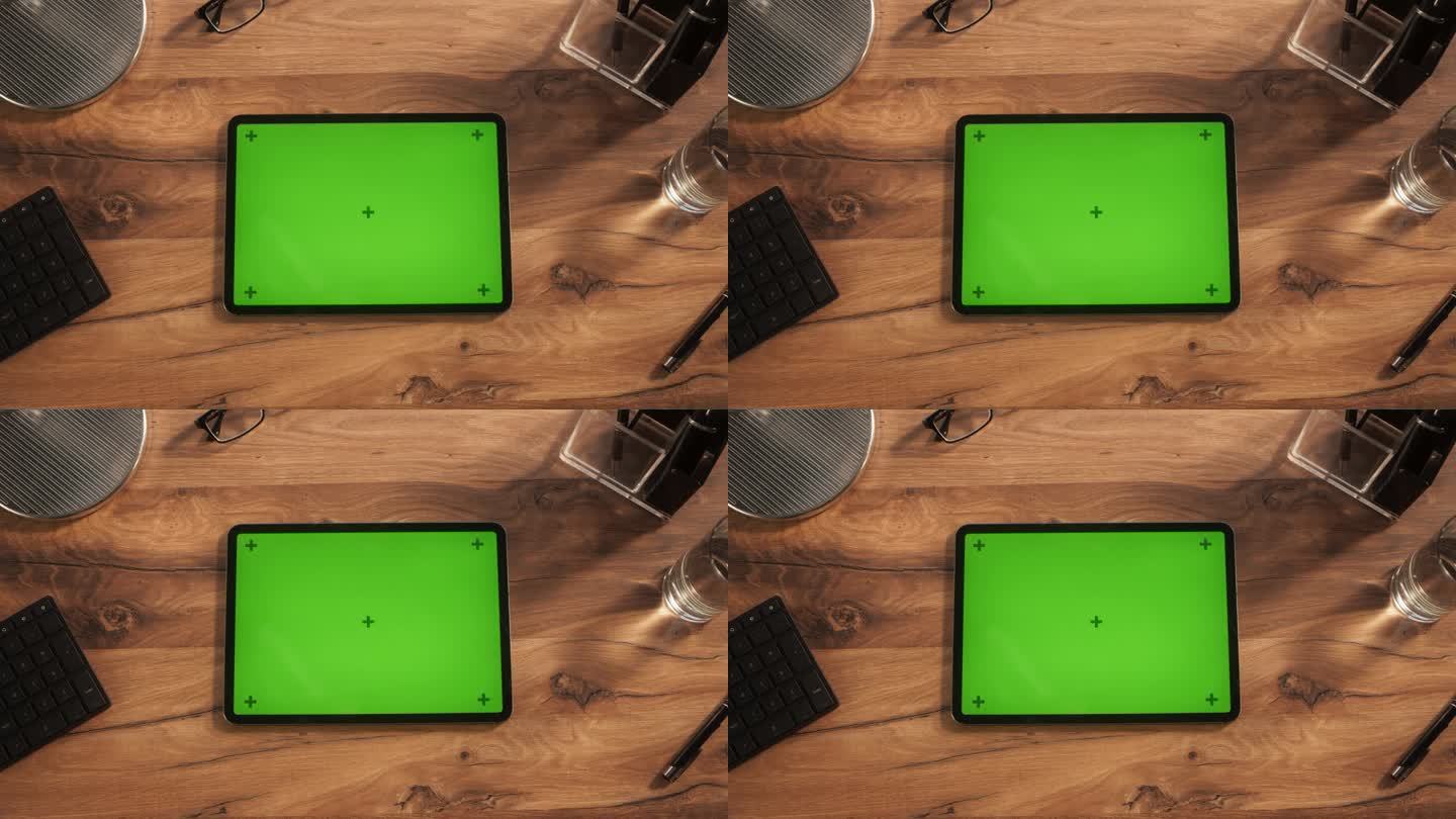 一个平板电脑与模拟绿色屏幕显示的自上而下的视图。设备水平放置在木制办公桌上的静态画面。在线教程和创意