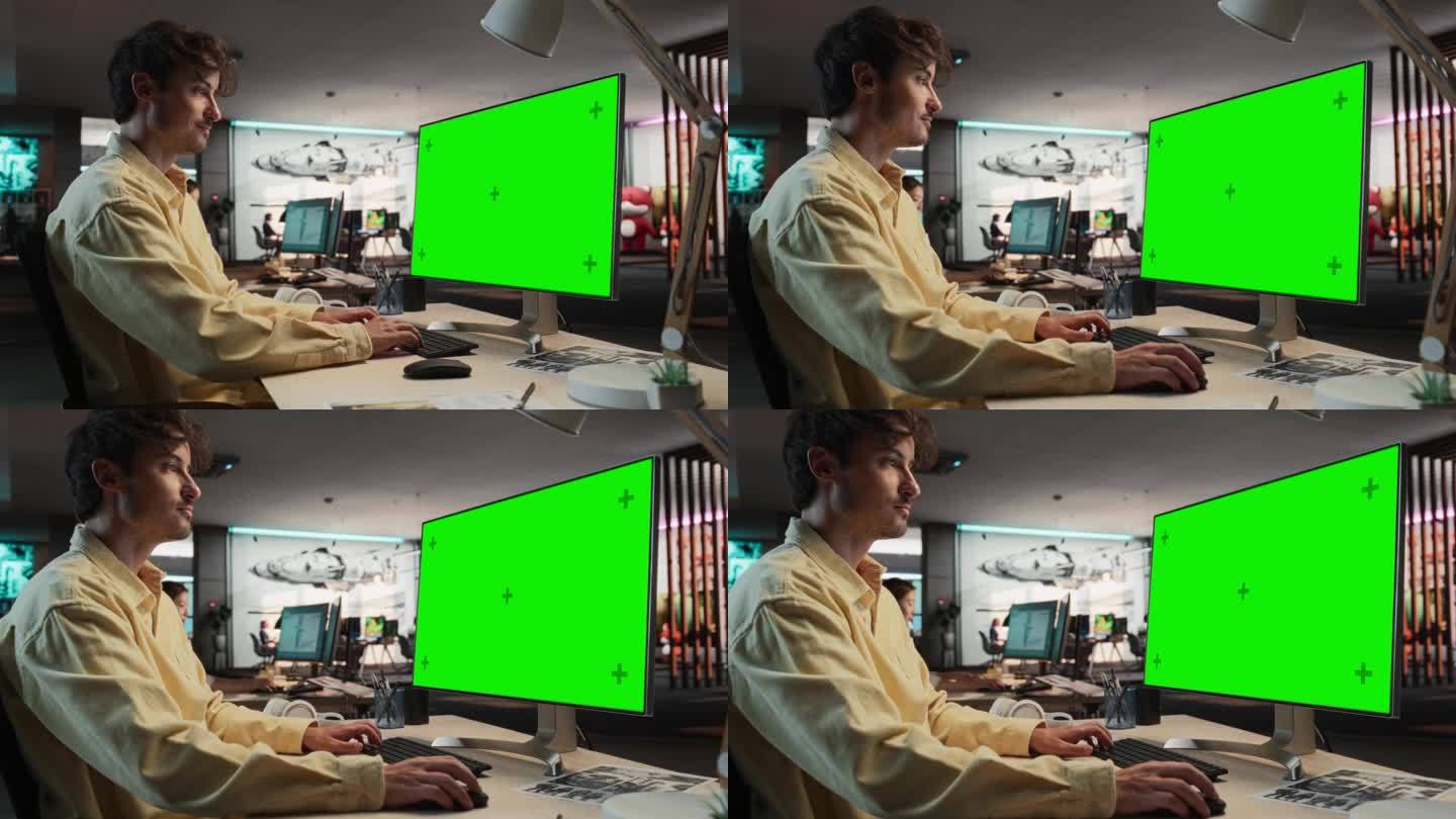 白人男子的肖像坐在他的办公桌上使用台式电脑与模拟绿屏铬。在游戏设计初创公司工作的男性游戏玩法动画师，