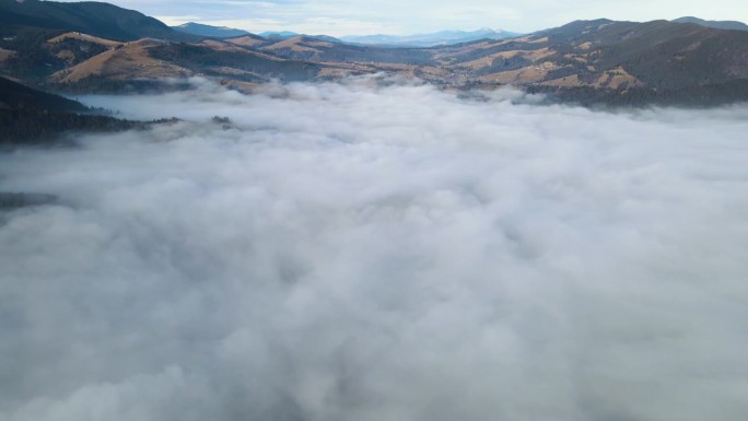 飞过山顶的云层。山峰高耸，清晨日出，自然景观优美