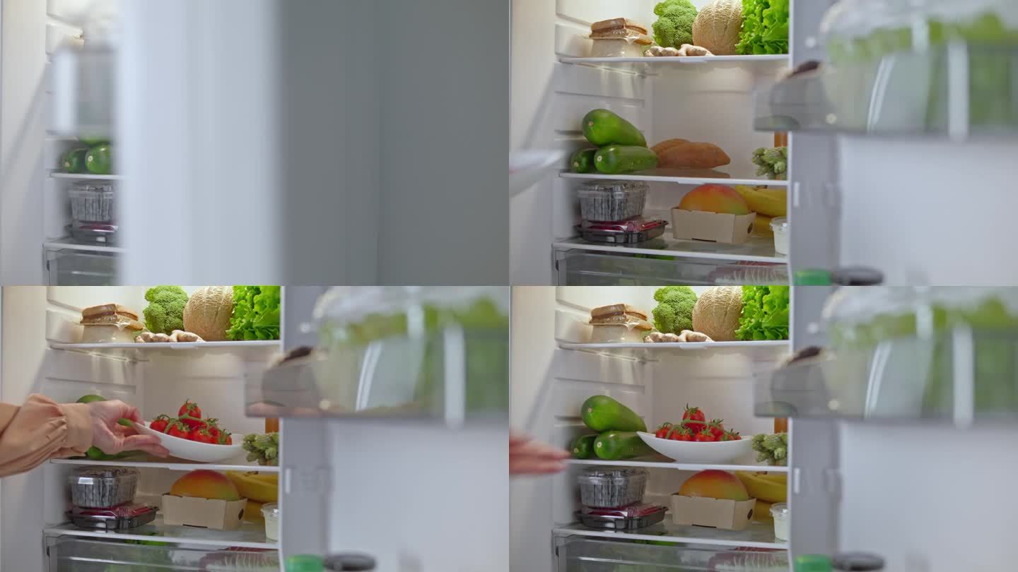 LD女性的手把一个装有西红柿的盘子放在冰箱的架子上