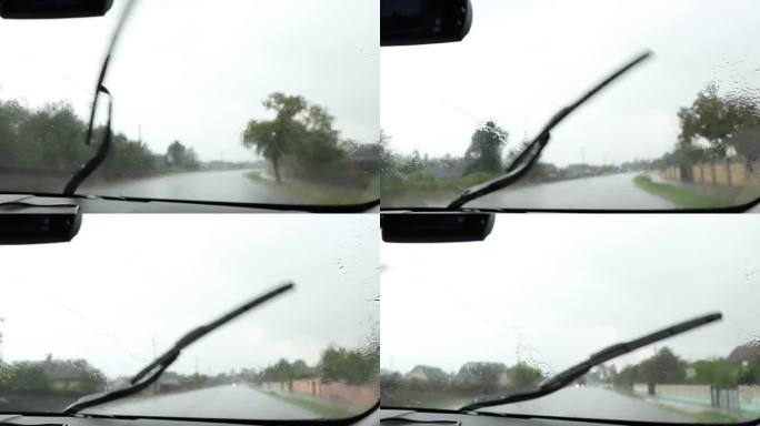 在乌克兰的一条公路上，一辆汽车上的雨刷擦去了一辆高速行驶的汽车上的雨水，这是一个夏日，从车内看，大雨