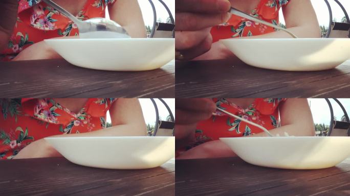 一个穿着鲜艳的女人在外面喝汤。特写镜头。