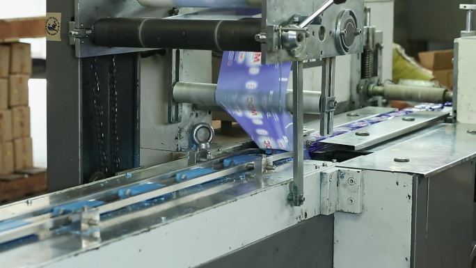 自动机器的特写，用印有商标的盖子包裹和密封肥皂