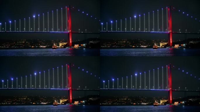 土耳其伊斯坦布尔，博斯普鲁斯大桥的夜景。从一艘漂浮的船上望去，灯火通明，桥上移动着汽车