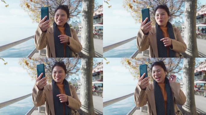 微笑的亚洲女性独自旅行者快乐地分享她精彩的旅行经历，视频通话，与朋友聊天，家庭旅行视频博主，在瑞士韦