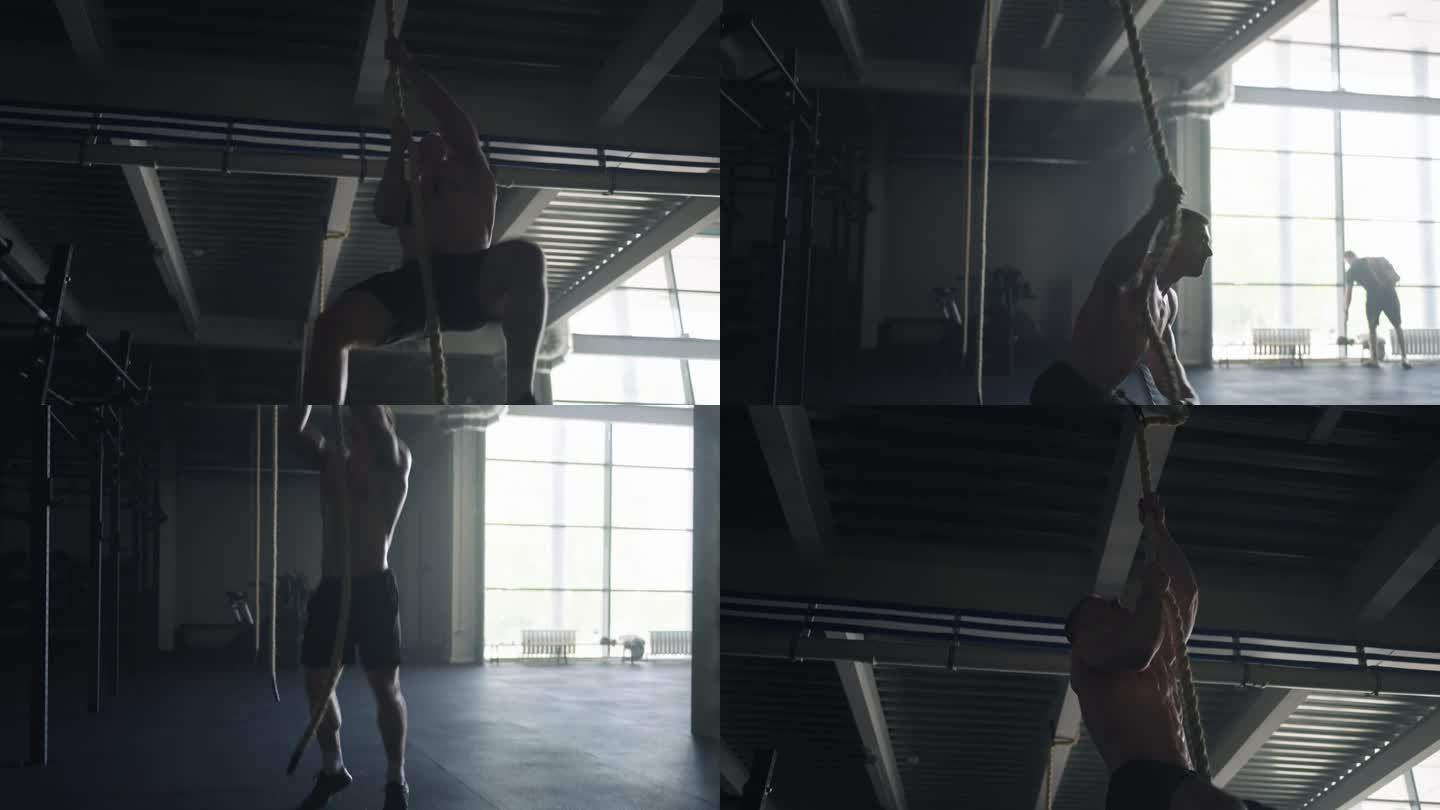 强壮的男人在健身房爬绳子，训练他的身体，赤裸的躯干与救济肌肉