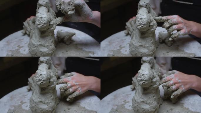 一个年轻的陶艺女孩在工作室的车间里用她的双手制作雕塑。粘土制成的女性雕像。女人完美的古色古香的身材。
