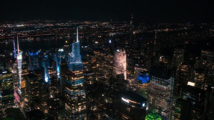 办公楼夜间航拍画面。在纽约，房间里亮着灯，商人和经理们长时间工作。直升机俯瞰曼哈顿的夜景