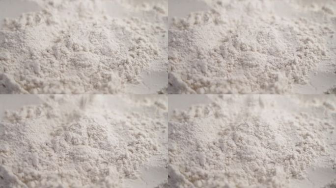 白色的米粉颗粒缓慢下落。膳食无麸质烘焙配料。旋转