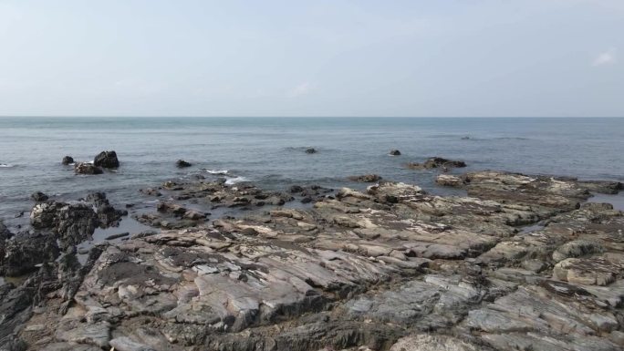 从空中俯瞰泰国平静的海滩上崎岖破碎的基岩