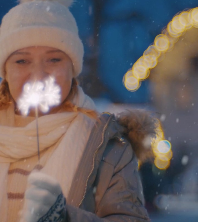 一名妇女在雪地里欣赏圣诞市场上耀眼的焰火