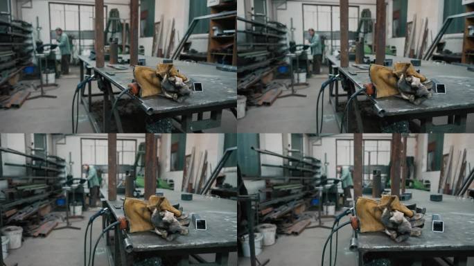金属工业工作台上脏手套和焊枪的SLO - MO特写