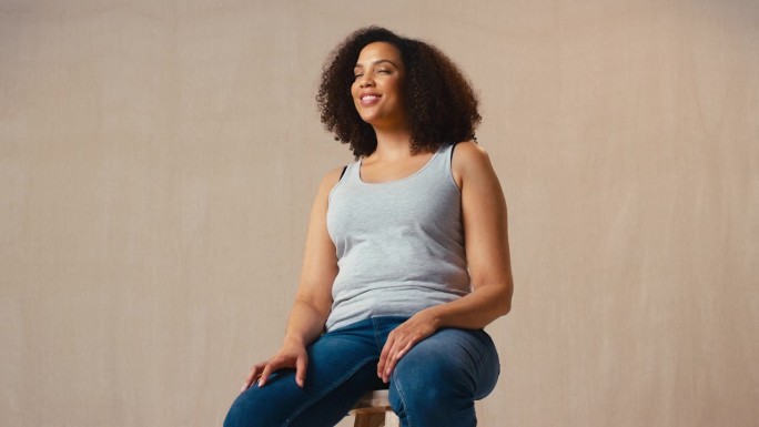 工作室肖像照片穿着随意的身体积极的女人坐在凳子上