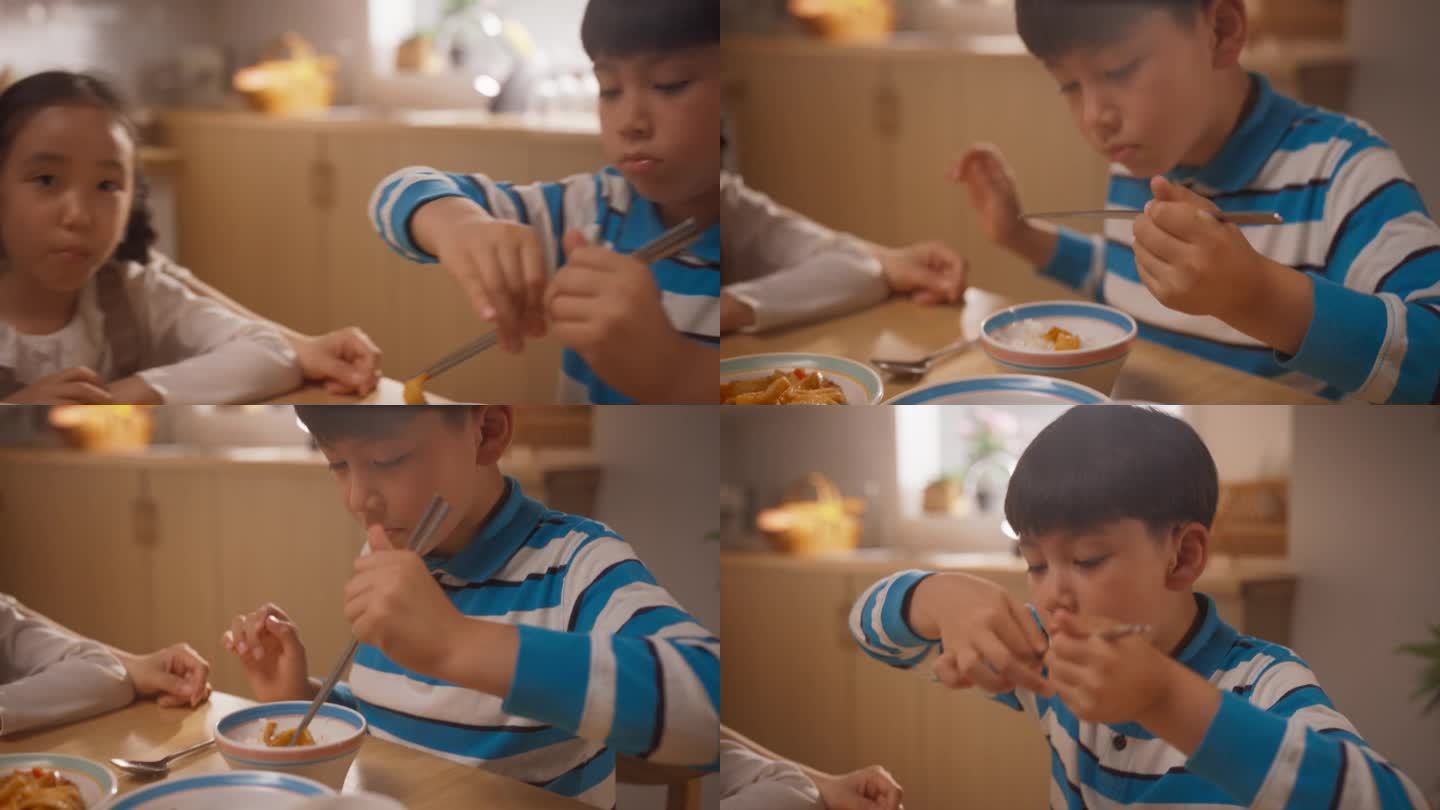 一个可爱的韩国男孩学习如何用筷子吃东西的特写。小男孩尽力用筷子吃他的美味早餐。有趣的情况