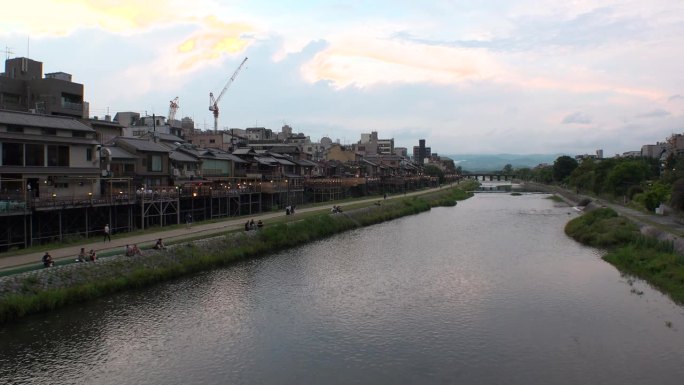 日本，京都:夕阳下的龟川和河原町市区。
