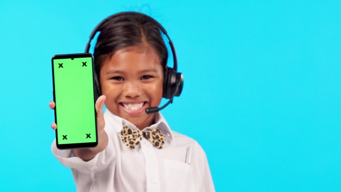 呼叫中心，一个女孩的画像，她拿着智能手机，戴着蓝色背景的绿屏耳机，很开心。广告或营销，样机空间或联系