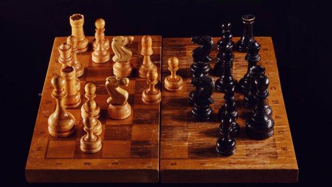 在中间游戏中玩旧棋子，停止动作。复古的国际象棋游戏与皇后开局黑色背景