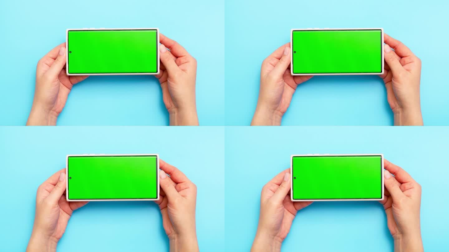 女子手持蓝屏绿屏智能手机