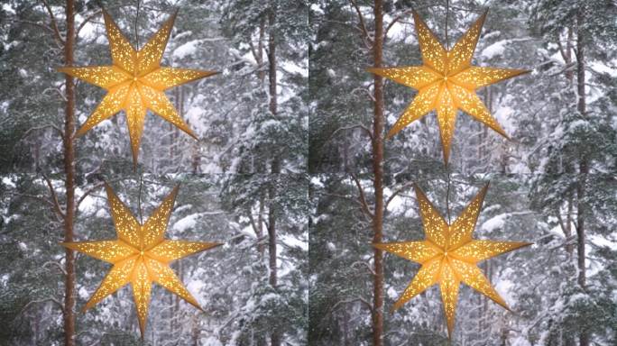 窗户上装饰的圣诞星星，背景是冬天的森林