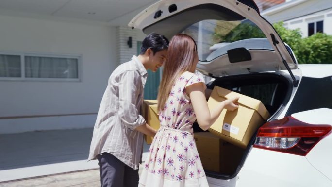 这个周末的早晨，一对年轻的亚洲夫妇正在打开他们的汽车后备箱，帮着搬行李，准备搬进新家。