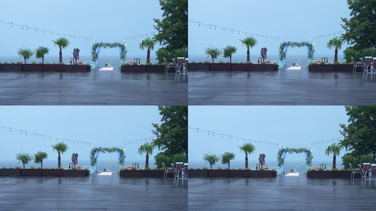 白色木制拱门和婚礼椅，在寒冷的雨中，在恶劣的天气条件下进行婚礼装饰