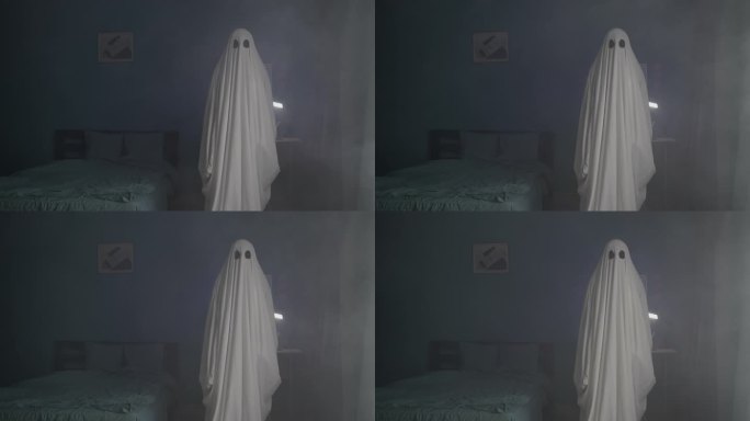 雾中黑暗房间里可怕的幽灵。披着被单的恶魔。万圣节的概念。