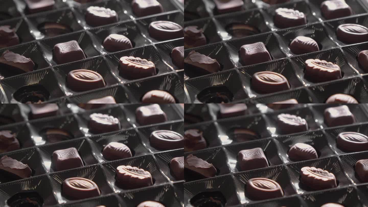 盒子里有各种形状的巧克力糖果。选择性对焦，慢动作。