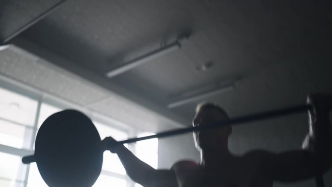 动力举重运动员在健身房的力量和能量，赤裸上身的男子举杠铃