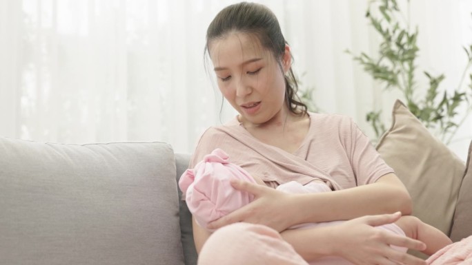 亚洲新生儿在家喝妈妈的奶。照顾幼儿的健康。饥饿时母乳喂养