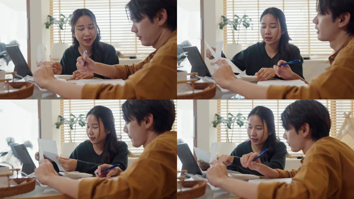 年轻夫妇使用数字平板电脑计划家庭预算。