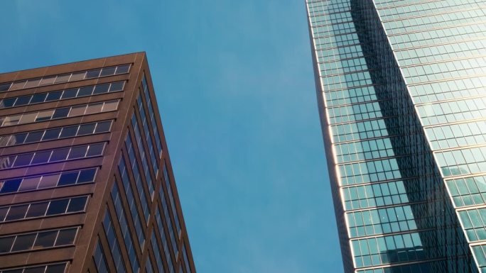 晴空万里的日子里，大城市的市中心金融区蓝镜玻璃商业大厦。低广角办公商业大楼从下面看商业大楼概念电影视