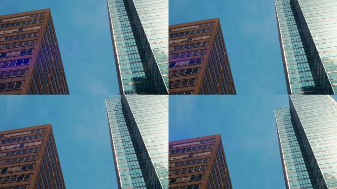 晴空万里的日子里，大城市的市中心金融区蓝镜玻璃商业大厦。低广角办公商业大楼从下面看商业大楼概念电影视