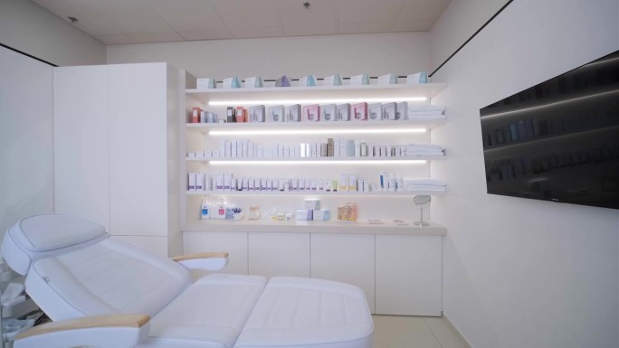 现代美容院里，美容师空荡荡的办公室里堆满了护理化妆品和按摩床。医疗柜内部。现代化的保健美容中心。模糊